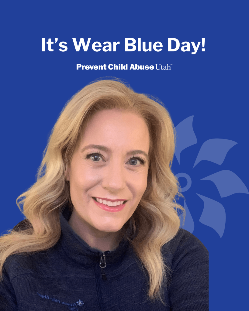 Smiling woman in a navy jacket on a blue background with text: “It’s Wear Blue Day! Prevent Child Abuse Utah.”